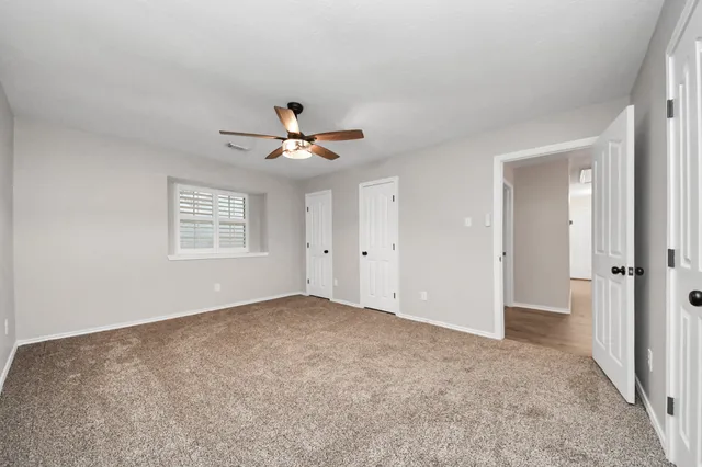 an empty room with a window and a fan