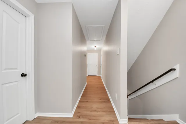 a view of a hallway with wooden floor and staircase