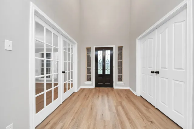 a view of a big room with wooden floor and windows
