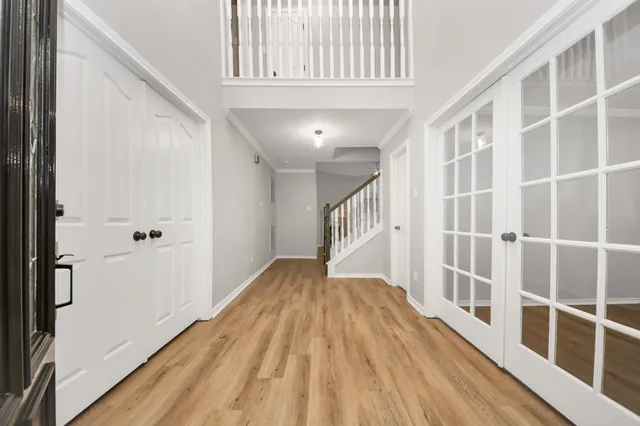 a view of a hallway with wooden floor and staircase