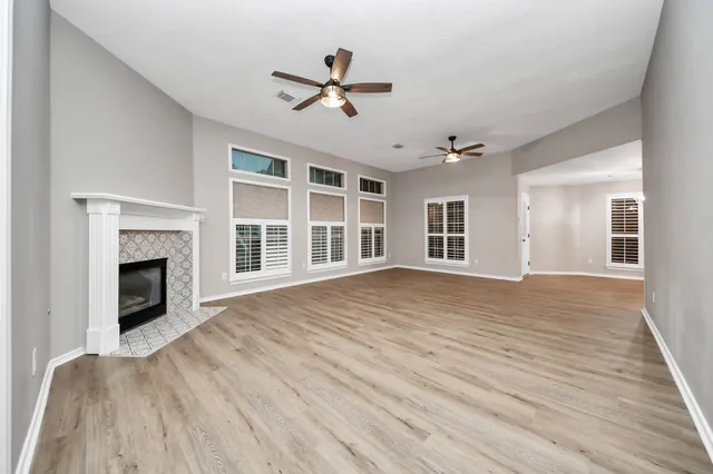 a view of empty room with wooden floor and fireplace