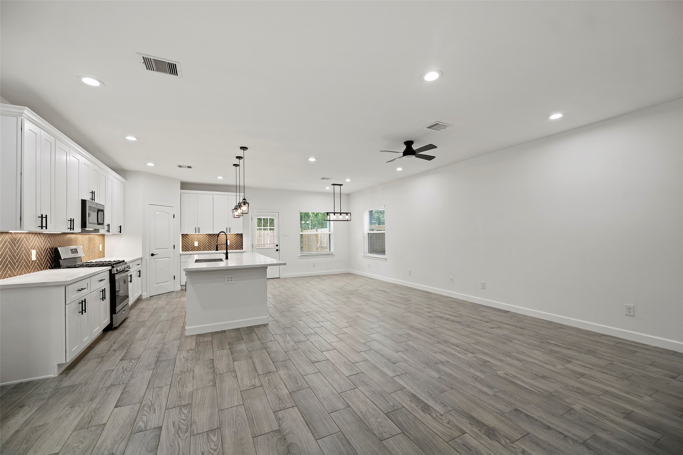 1071 St Clair Street Houston, TX 77088 - Photo 5 of 31 a large white kitchen with wooden floors and white walls