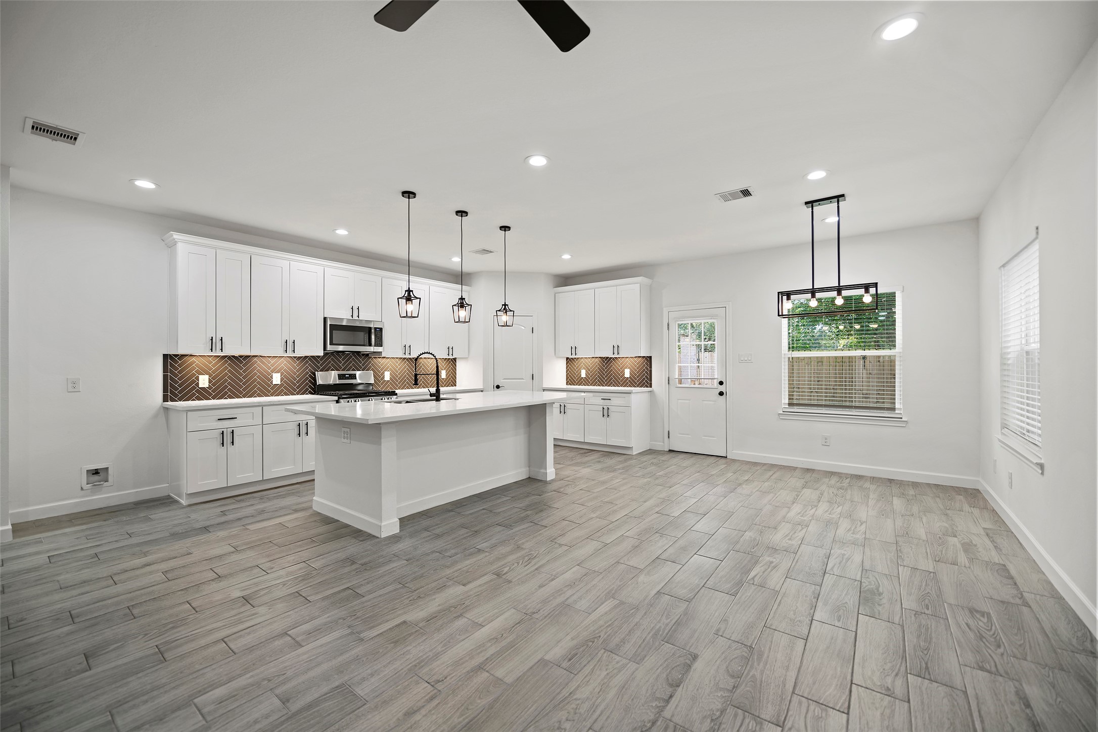 1071 St Clair Street Houston, TX 77088 - Photo 6 of 31 a large kitchen with white cabinets stainless steel appliances a window and kitchen view