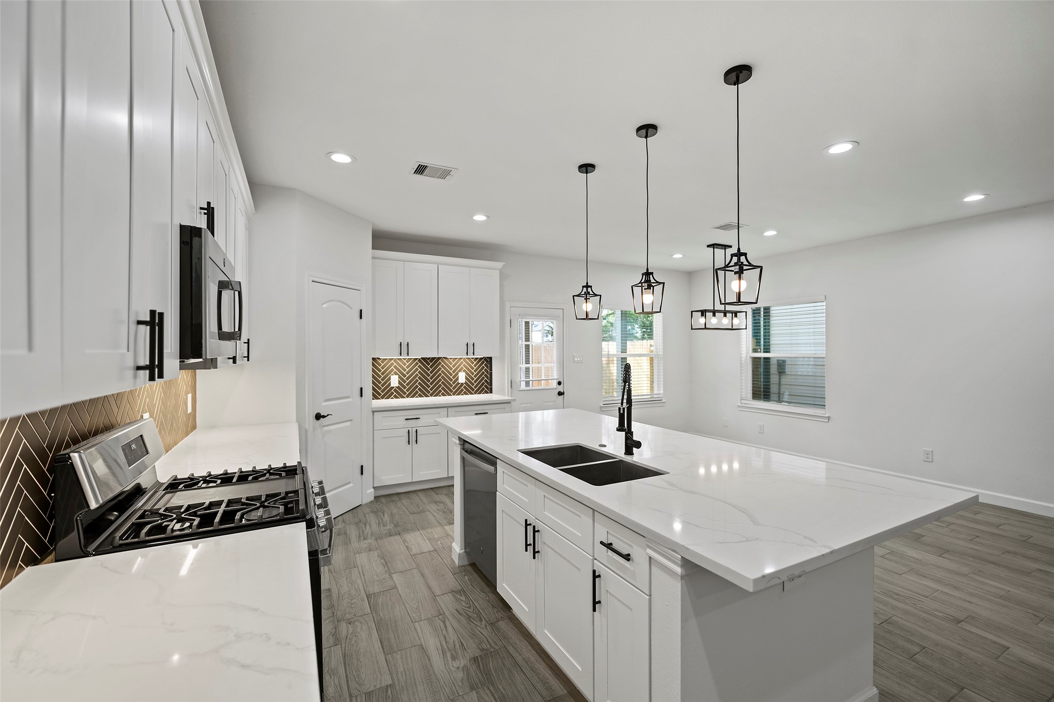 1071 St Clair Street Houston, TX 77088 - Photo 9 of 31 a large kitchen with stainless steel appliances kitchen island granite countertop a sink a stove and a refrigerator