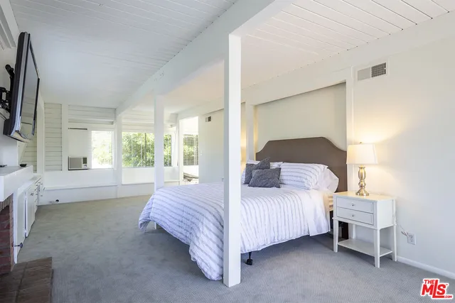 a bed room with a bed and a large window