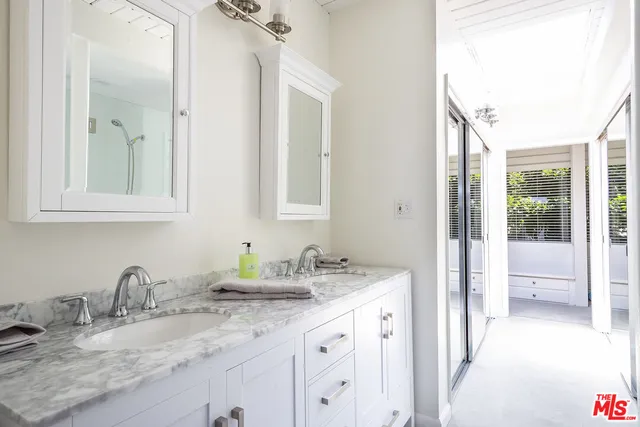 a bathroom with double vanity sink and a mirror