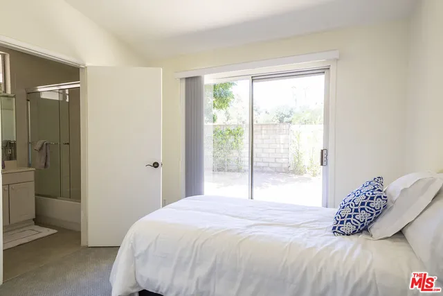 a bedroom with a bed and a large window