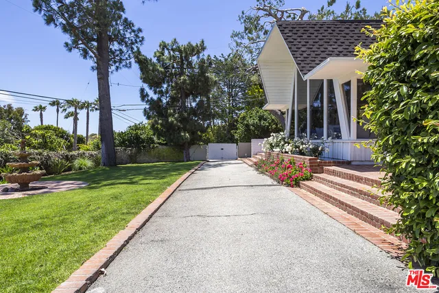 a view of a patio with couches table and chairs and potted plants