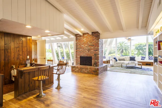a living room with fireplace furniture and a large window