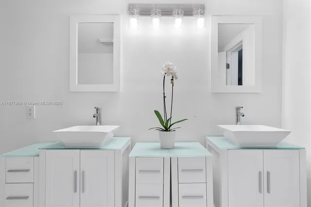 a spacious bathroom with a double vanity sink a toilet and mirror