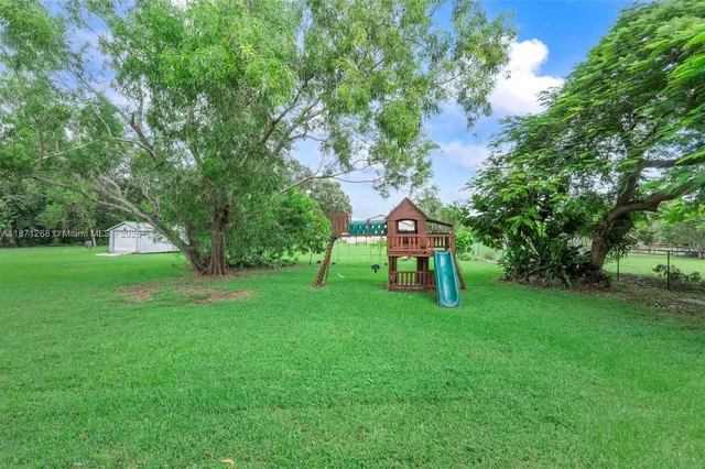 a green field with lots of trees in it