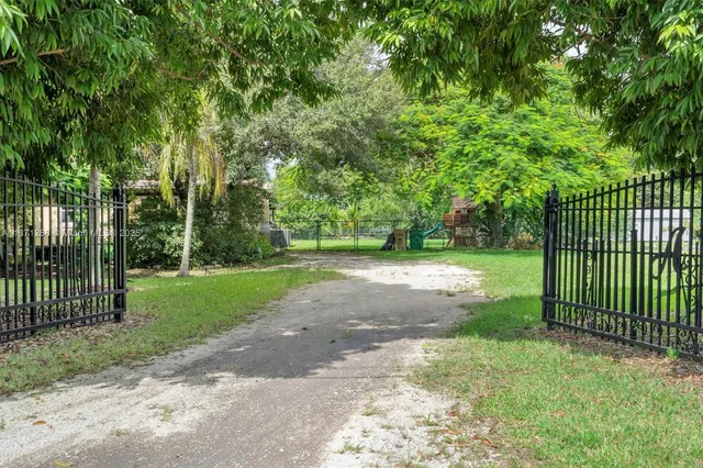 a view of a house with a big yard and large trees