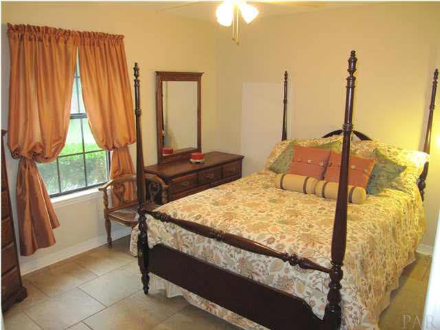5918 Country Club Road Milton, FL 32570 - Photo 23 of 25 Additional bedroom at back of home. Lighted ceiling fan. Window view to lushly landscaped back yard.