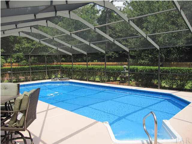 5918 Country Club Road Milton, FL 32570 - Photo 8 of 25 View of pool from screen door leading to side yard. Notice the wooded private view to right which is the back property line.