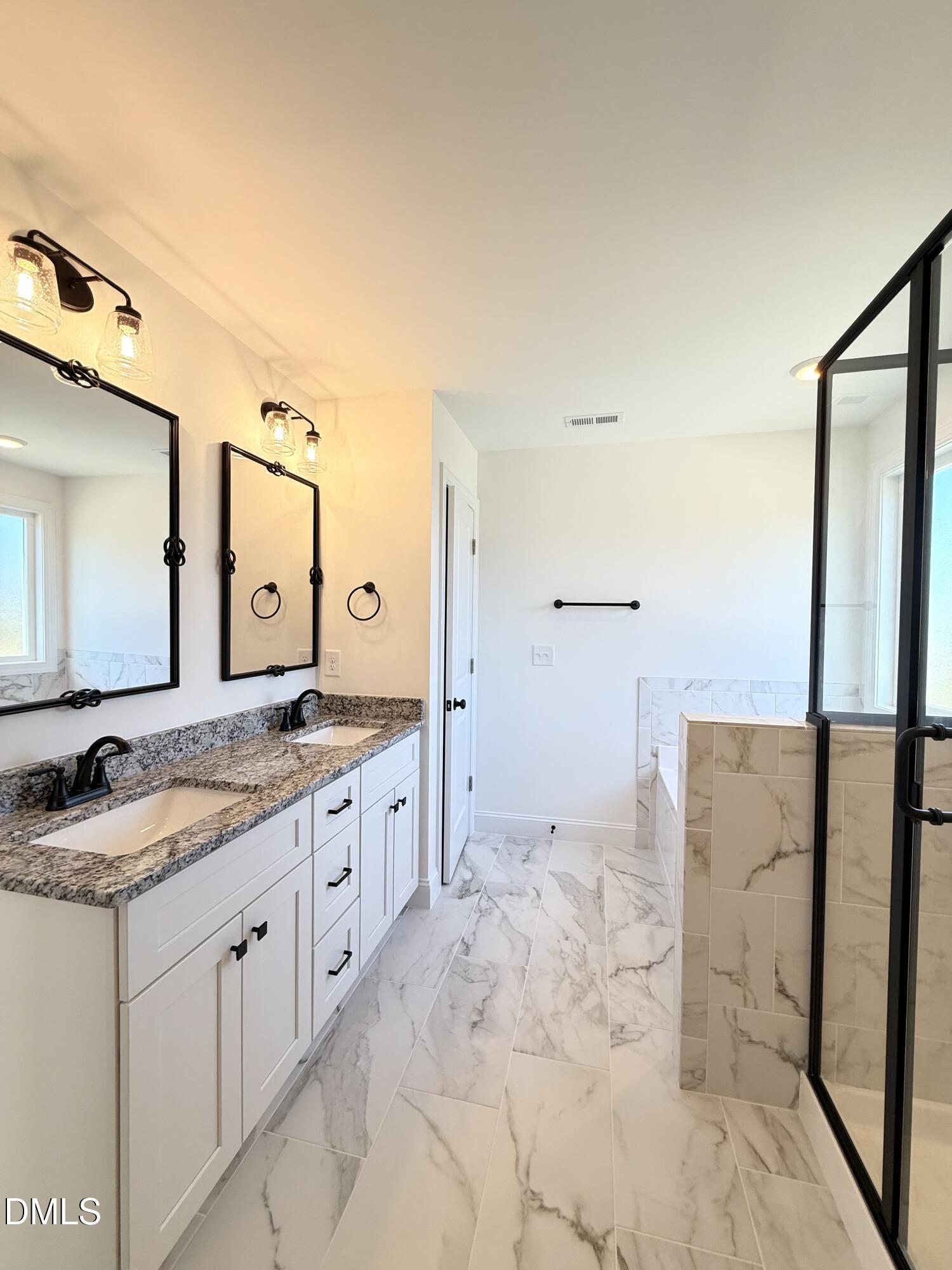 6800 Fire Tower Road Spring Hope, NC 27882 - Photo 22 of 36 a spacious bathroom with a granite countertop sink a mirror and a shower