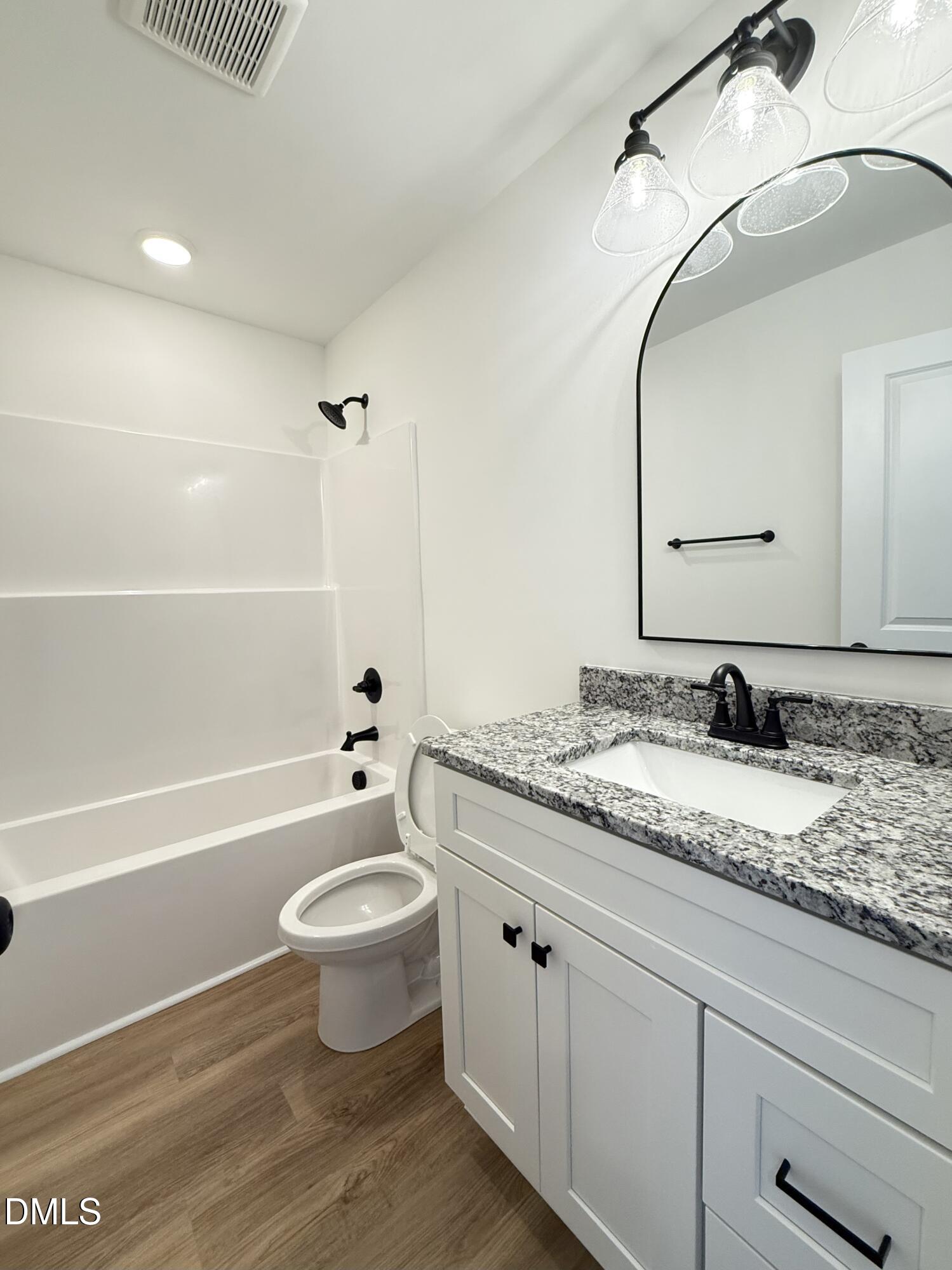 6800 Fire Tower Road Spring Hope, NC 27882 - Photo 28 of 36 a bathroom with a granite countertop sink a toilet and a mirror