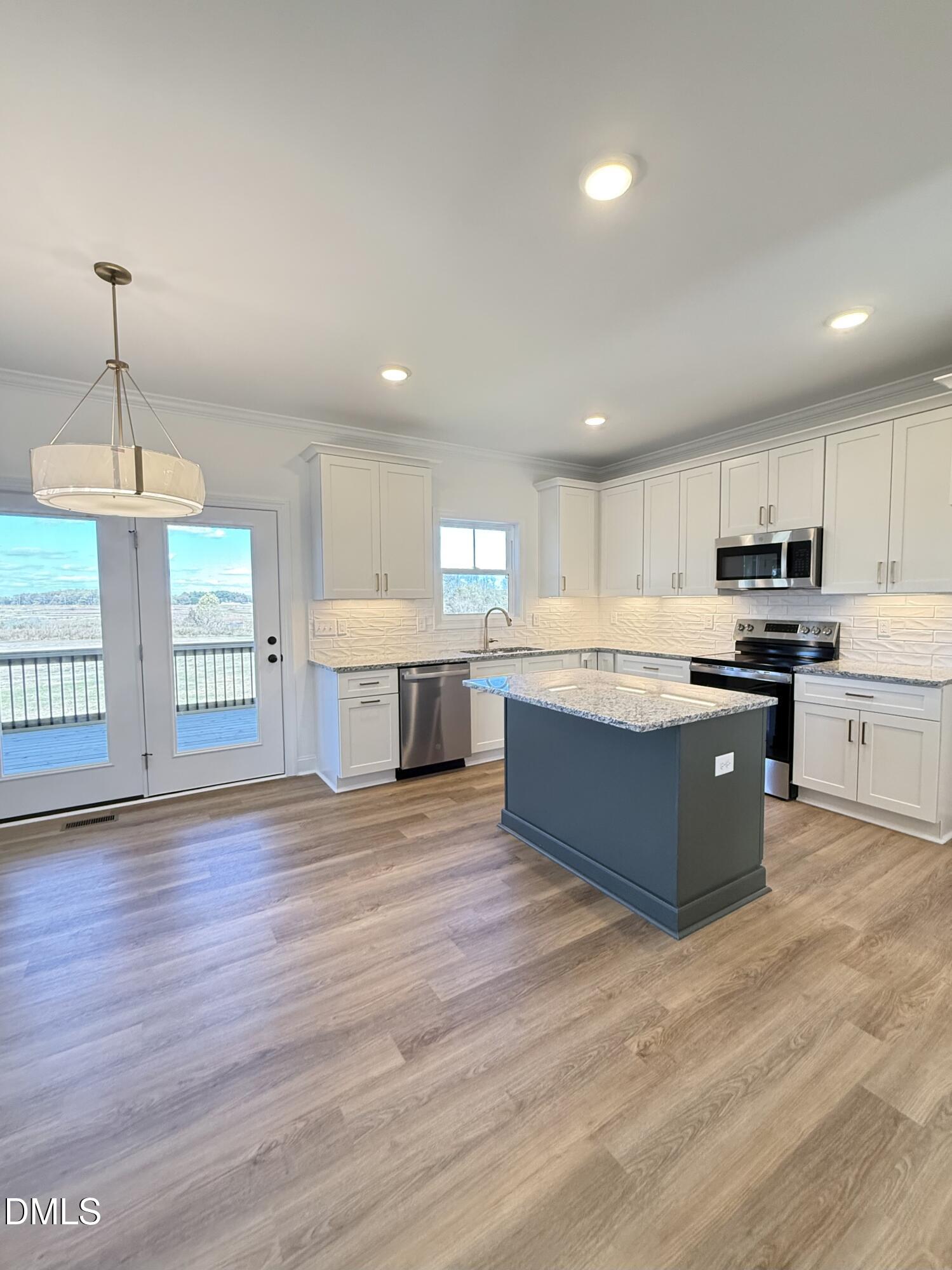6800 Fire Tower Road Spring Hope, NC 27882 - Photo 10 of 36 a large kitchen with stainless steel appliances kitchen island a large counter top and a wooden floors