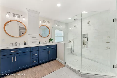 a bathroom with a double vanity sink double mirror and shower