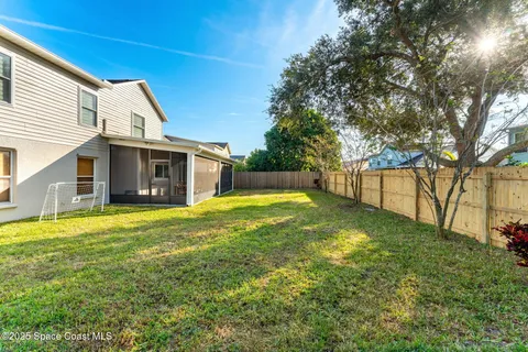 a view of a house with a backyard and a tree