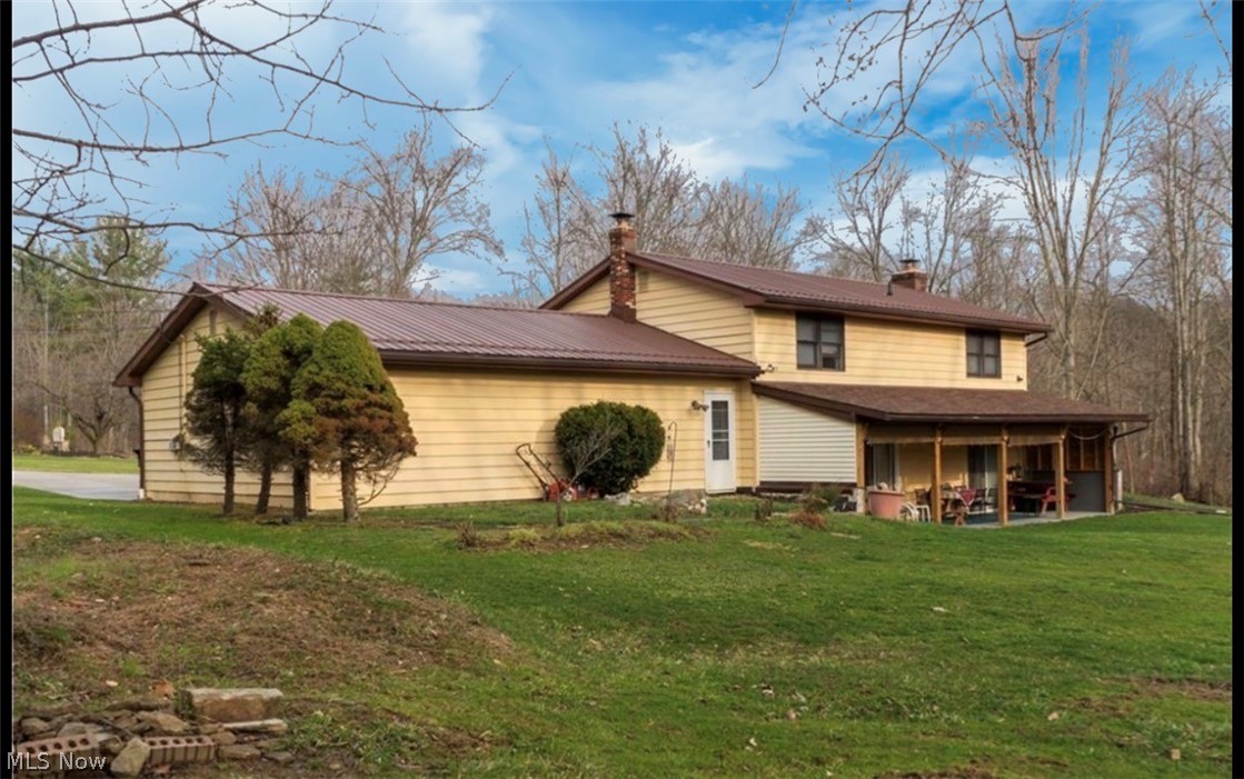 871 South County Line Road Geneva, OH 44041 - Photo 5 of 20 View of front facade featuring a chimney, a front lawn, and a patio