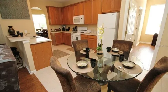 a kitchen with furniture a refrigerator and a dining table