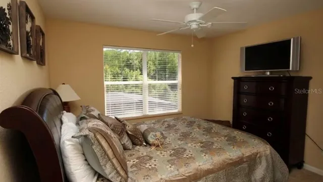 a bedroom with a bed and a flat tv screen on dresser