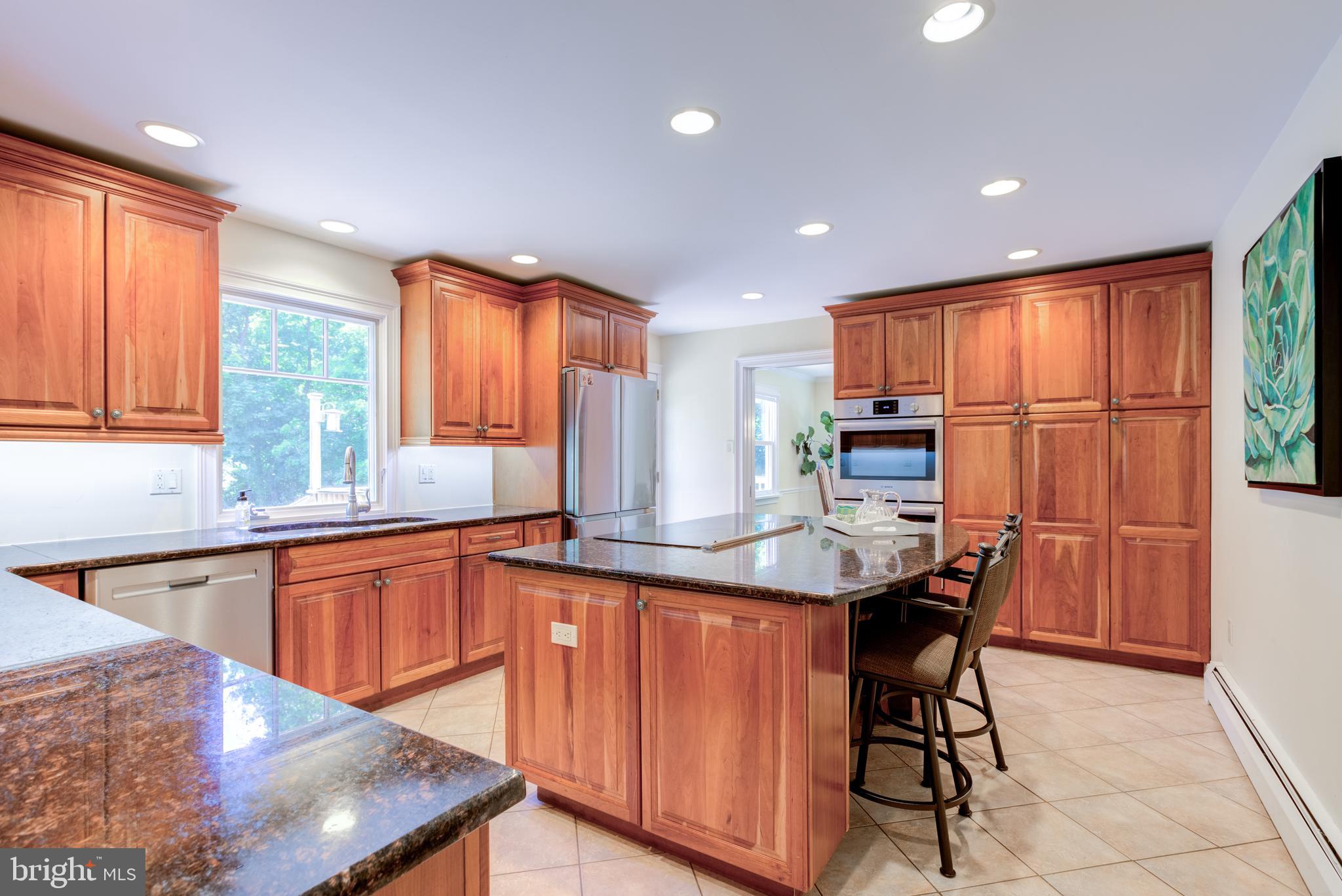 420 Accomac Road Wyncote, PA 19095 - Photo 16 of 82 a kitchen with stainless steel appliances kitchen island granite countertop a table chairs in it and wooden floors