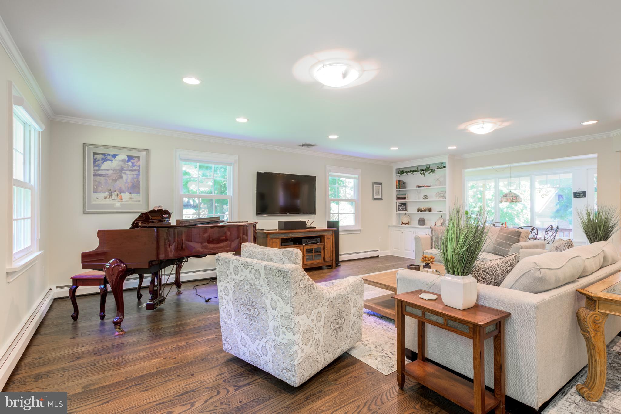 420 Accomac Road Wyncote, PA 19095 - Photo 28 of 82 a living room with furniture a wooden floor and a flat screen tv