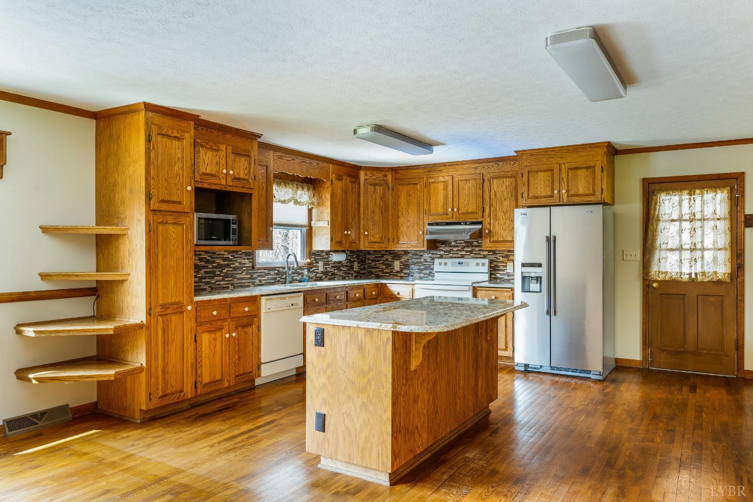 129 Quail Ridge Drive Altavista, VA 24517 - Photo 12 of 76 a kitchen with stainless steel appliances granite countertop a refrigerator a sink dishwasher a stove with wooden cabinets and floor