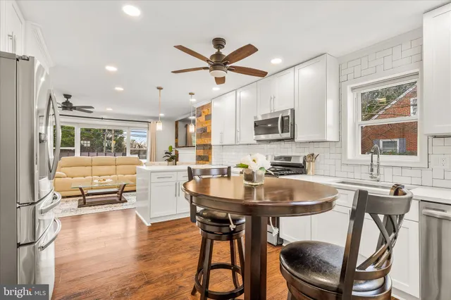 a kitchen with a dining table chairs and sink