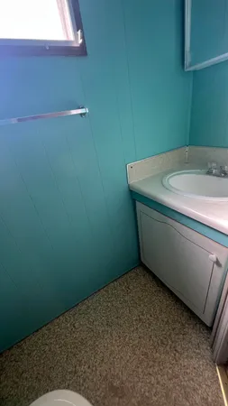 a white toilet sitting next to a small window