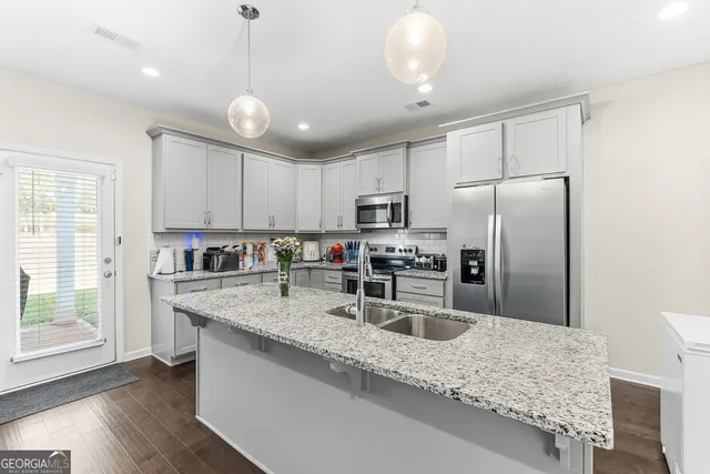 a kitchen with stainless steel appliances granite countertop a sink stove and refrigerator