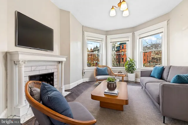 a view of a livingroom with wooden floor and a fireplace