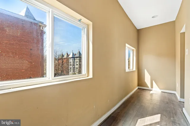 an empty room with windows and fan