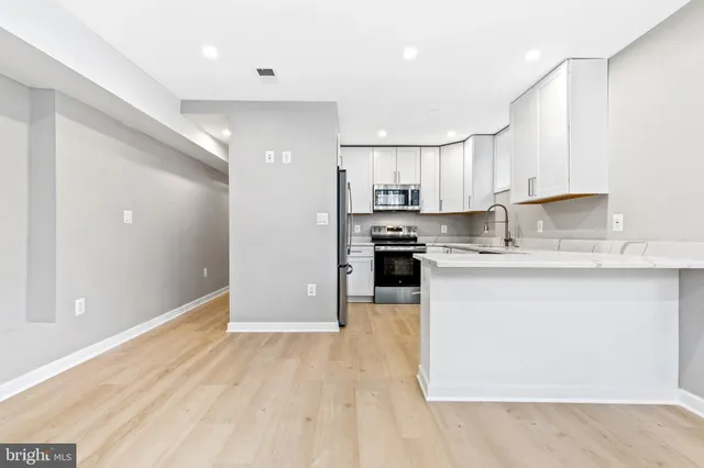 a kitchen with granite countertop a stove a sink and a microwave