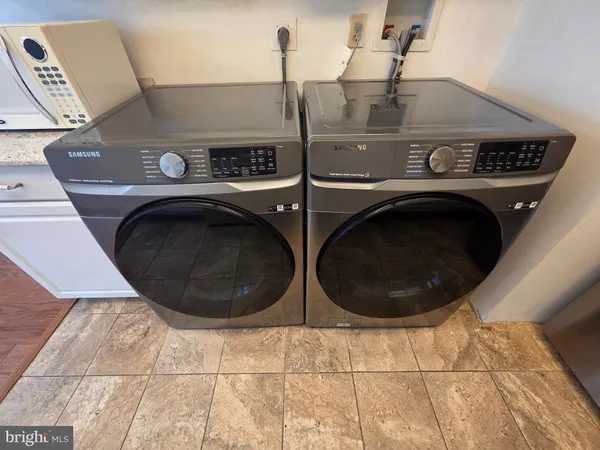 a kitchen with stainless steel appliances granite countertop a refrigerator a stove and a sink with wooden floor