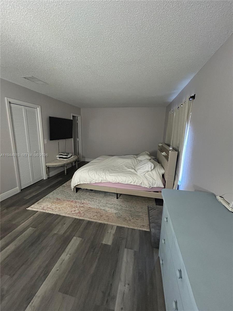 7402 Northwest 75th Street Tamarac, FL 33321 - Photo 12 of 38 a bedroom with a bed and a flat tv screen on dresser