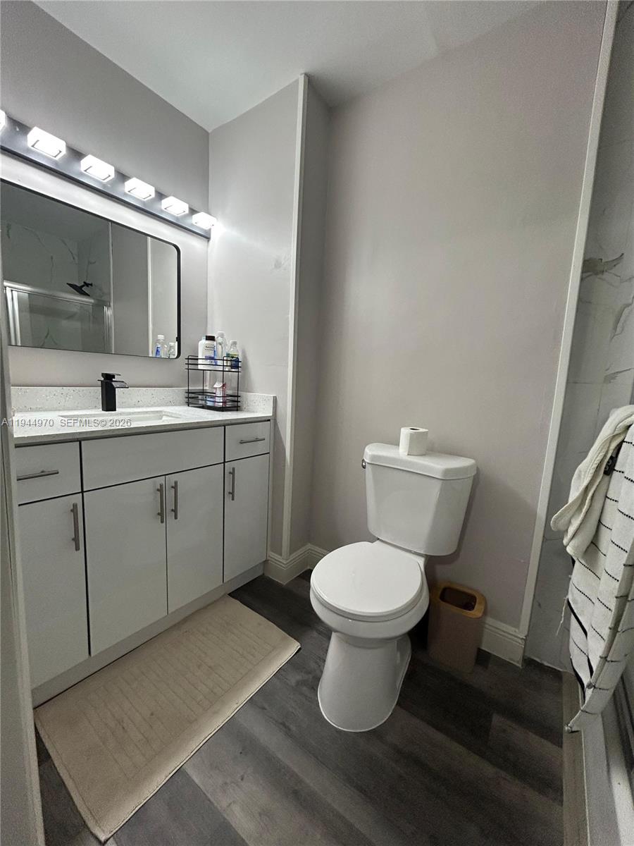7402 Northwest 75th Street Tamarac, FL 33321 - Photo 21 of 38 a bathroom with a toilet sink a mirror and vanity