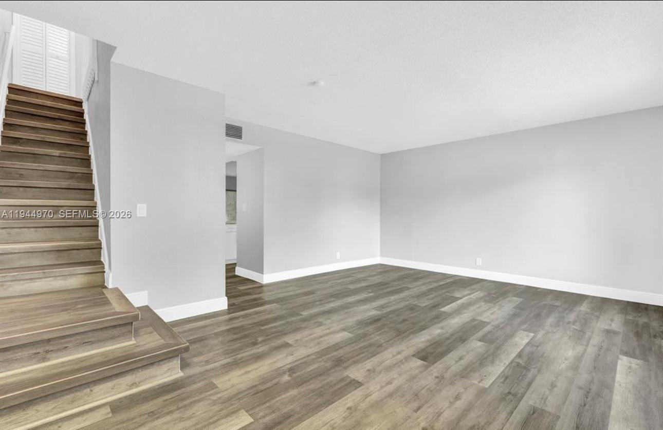 7402 Northwest 75th Street Tamarac, FL 33321 - Photo 31 of 38 a view of an empty room with wooden floor and stairs
