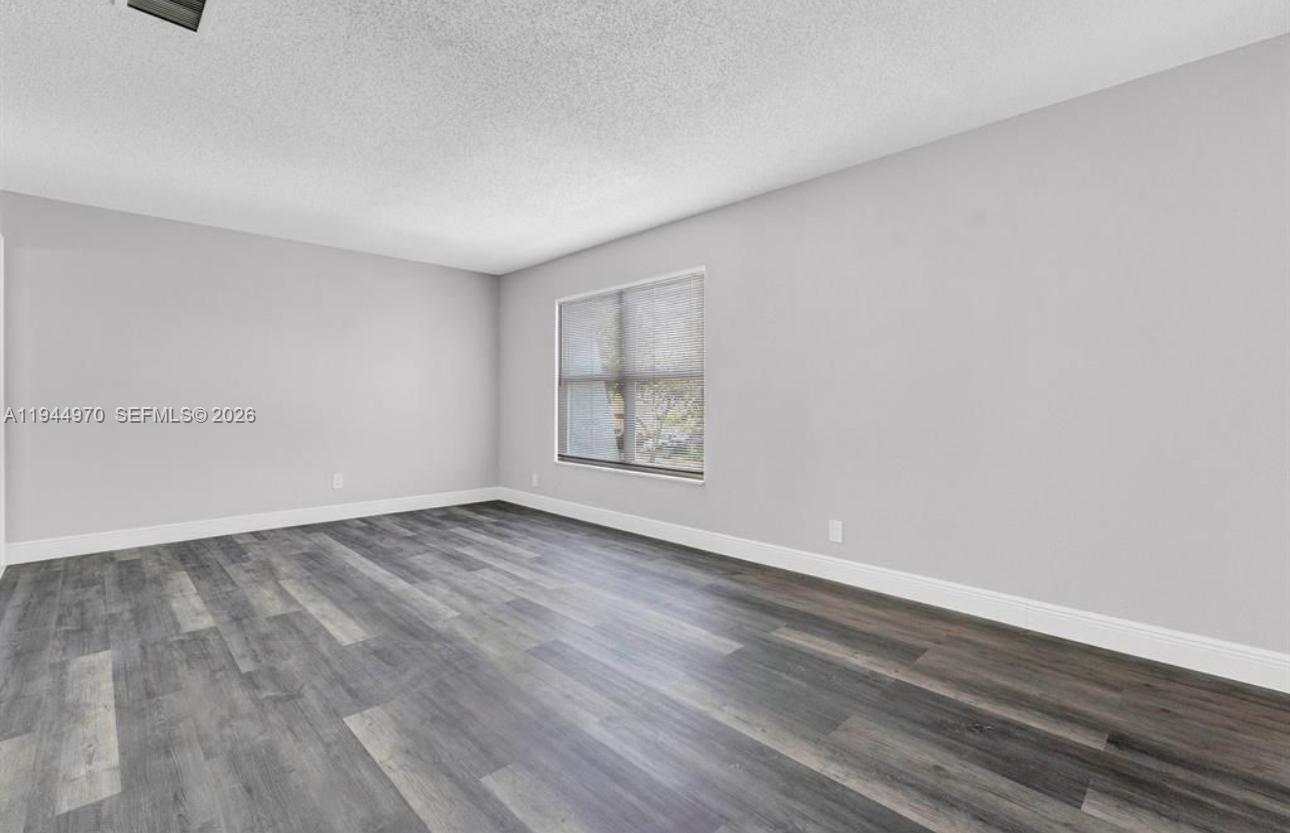 7402 Northwest 75th Street Tamarac, FL 33321 - Photo 36 of 38 a view of an empty room and wooden floor