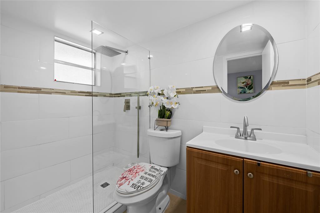471 North Pine Island Road, Unit 302D Plantation, FL 33324 - Photo 11 of 23 a bathroom with a toilet a sink and a mirror
