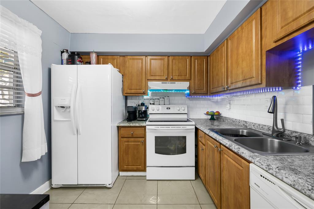 471 North Pine Island Road, Unit 302D Plantation, FL 33324 - Photo 7 of 23 a kitchen with a refrigerator sink and cabinets