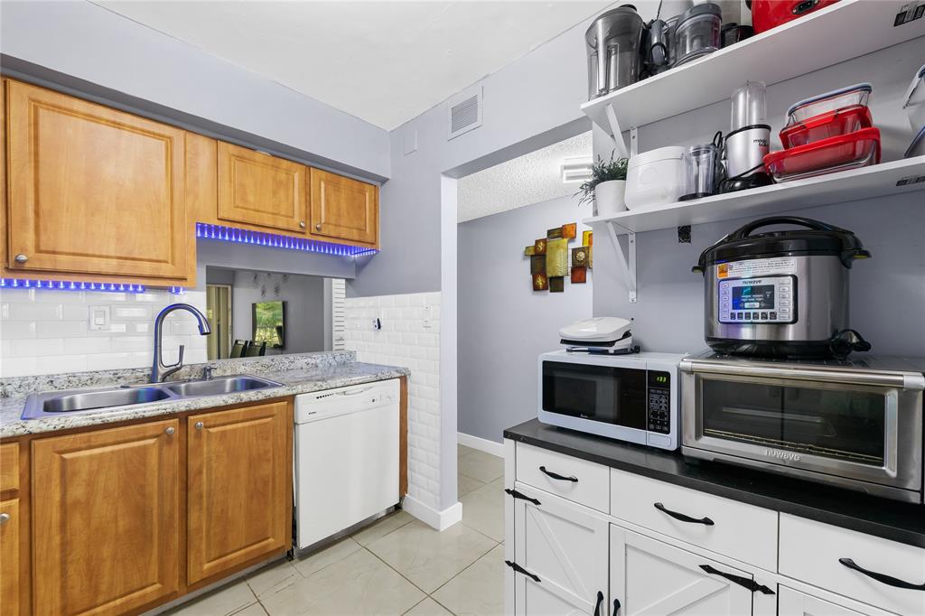 471 North Pine Island Road, Unit 302D Plantation, FL 33324 - Photo 8 of 23 a kitchen with stainless steel appliances granite countertop a sink and a stove