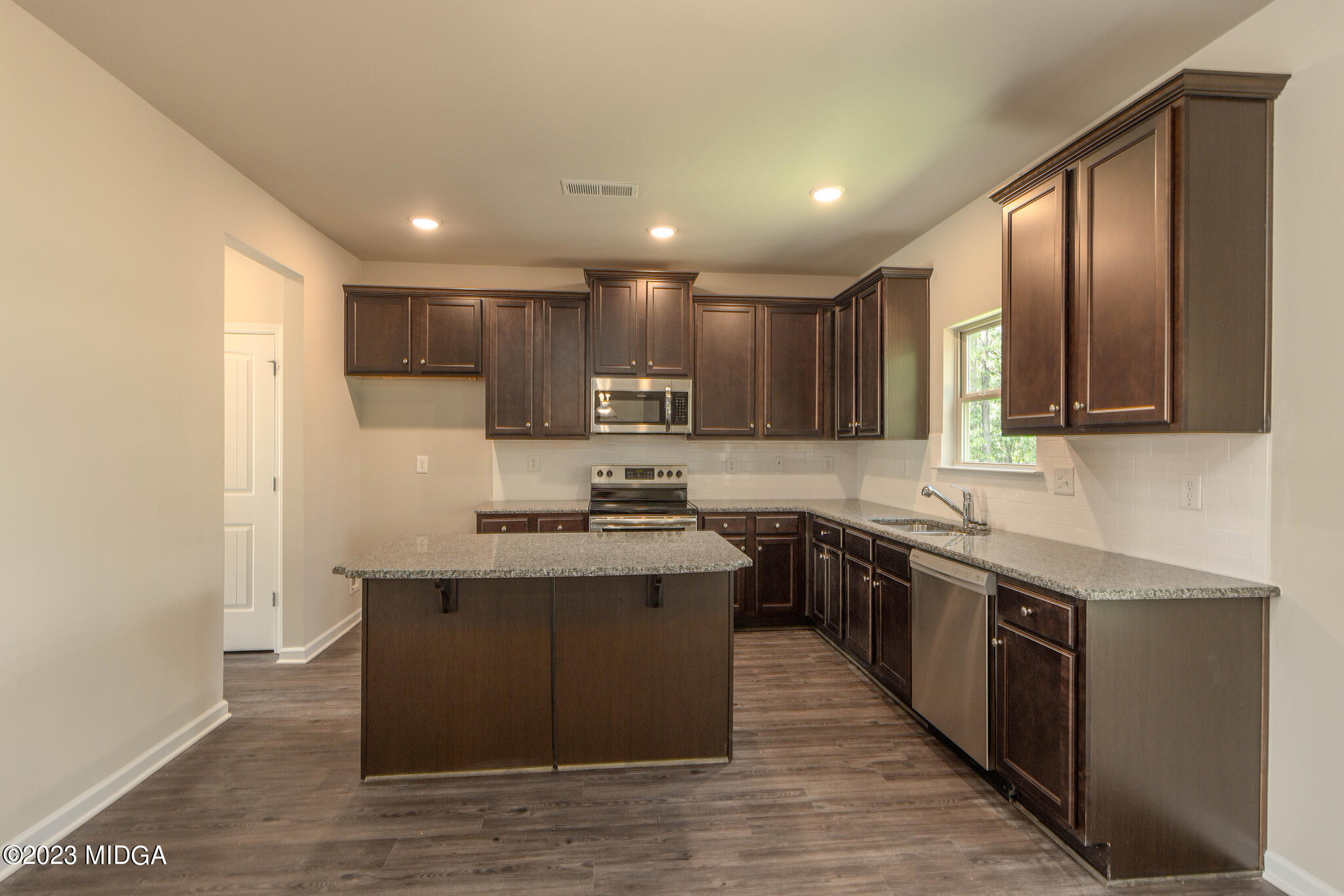 155 Cherokee Rose Drive Jackson, GA 30233 - Photo 12 of 32 a kitchen with stainless steel appliances granite countertop a sink stove and refrigerator