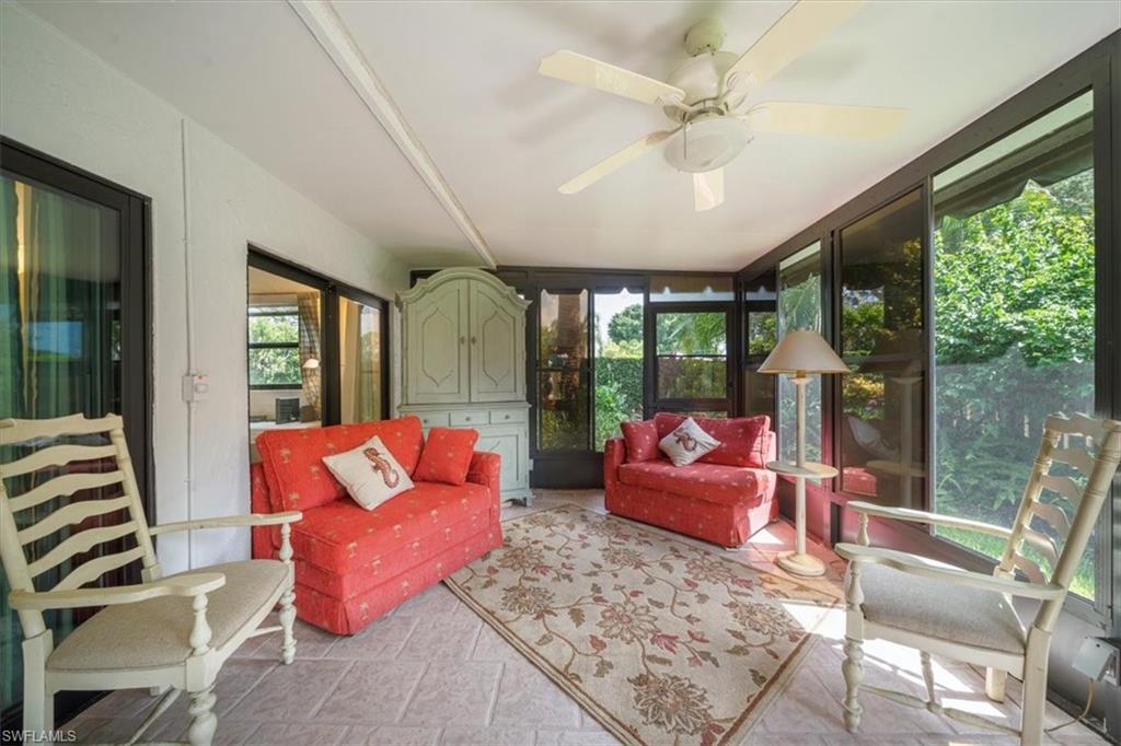 811 Reef Point Circle, Unit 90 Naples, FL 34108 - Photo 13 of 28 a living room with patio furniture and a large window