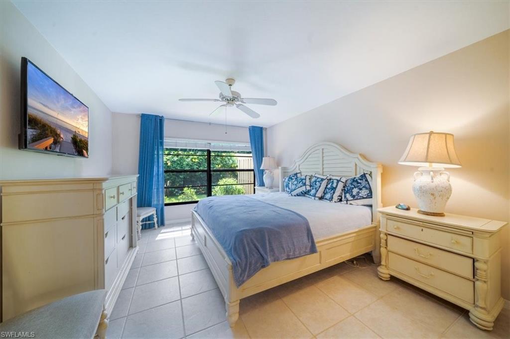 811 Reef Point Circle, Unit 90 Naples, FL 34108 - Photo 17 of 28 a bedroom with a bed and a flat screen tv