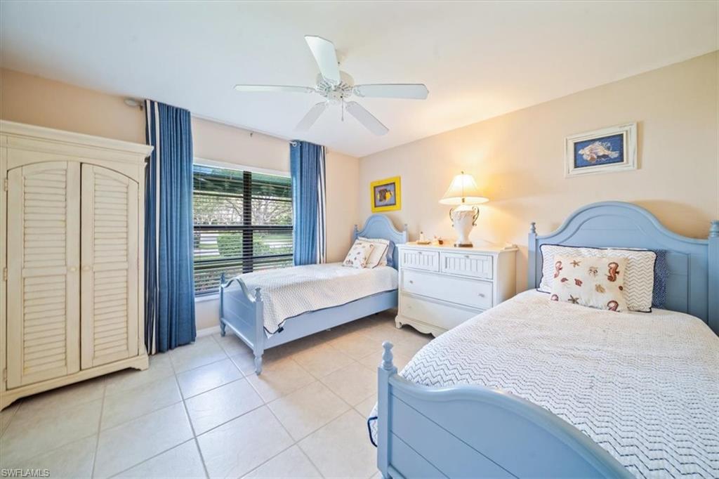 811 Reef Point Circle, Unit 90 Naples, FL 34108 - Photo 21 of 28 a spacious bedroom with two beds and a chandelier