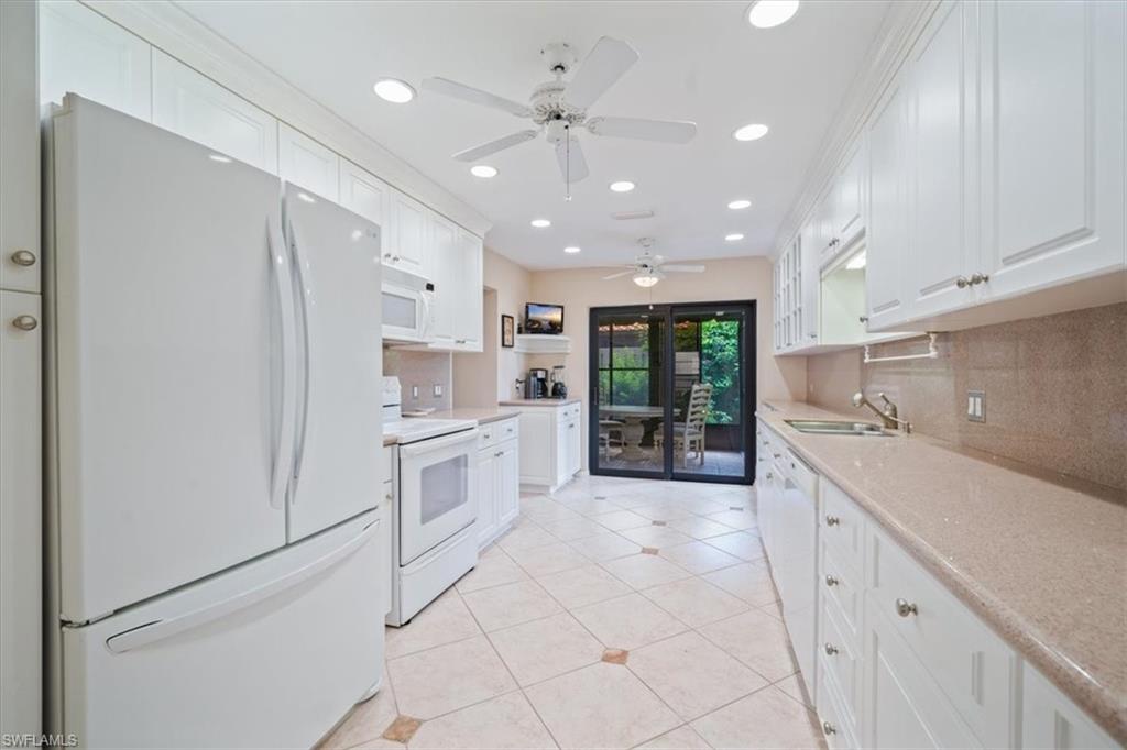 811 Reef Point Circle, Unit 90 Naples, FL 34108 - Photo 4 of 28 a kitchen with white cabinets and white appliances