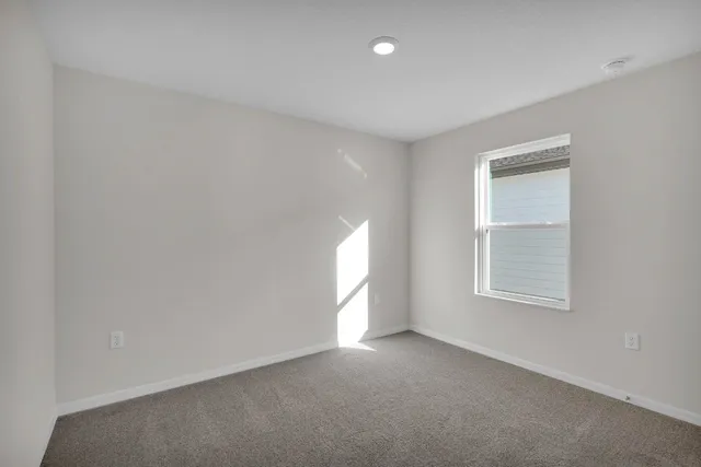 an empty room with a window and closet