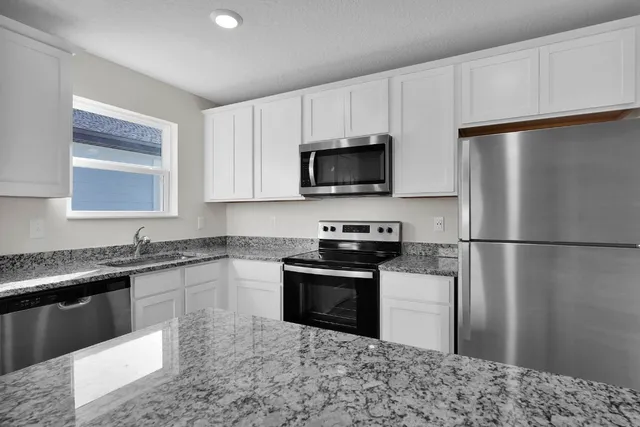 a kitchen with a refrigerator stove and sink